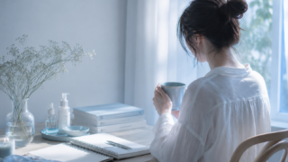 自分を整える時間をイメージした部屋で、ノートと美容アイテムに囲まれて過ごす女性
